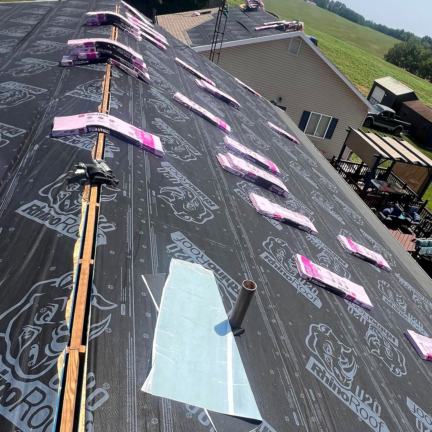 Synthetic underlayment and shingle bundles staged during install