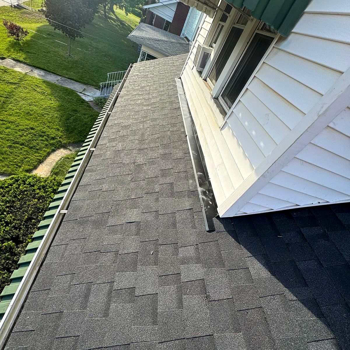 New shingles and sidewall flashing along siding