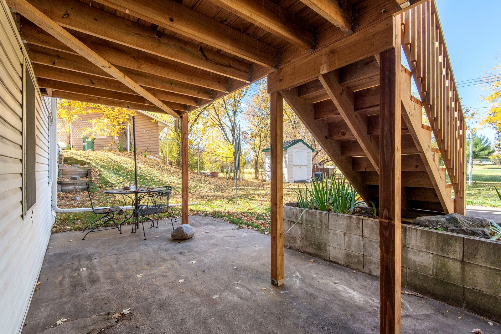 Underside of a raised deck showing the joists, beams, posts and stair stringers