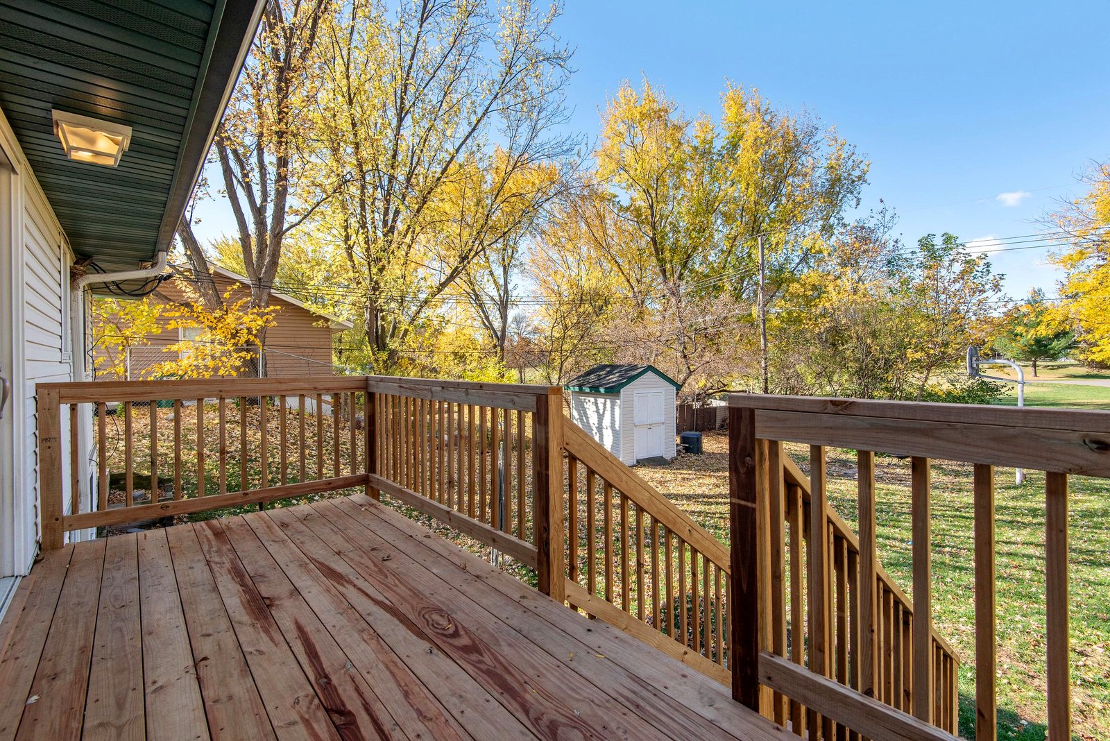 Wood deck railing with balusters running down the stair rail
