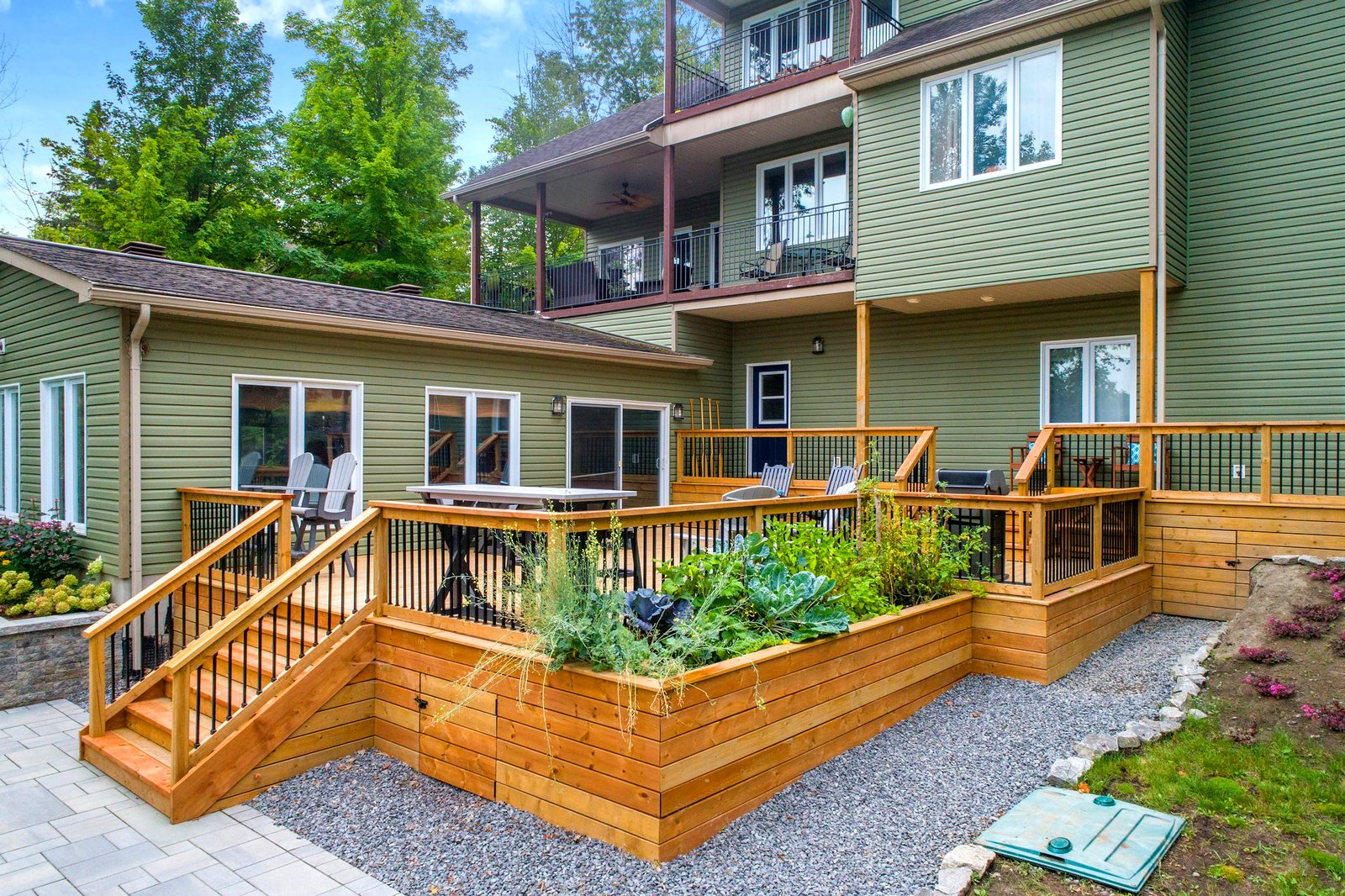 Multi-level cedar deck with built-in planters and wide stairs down to the patio
