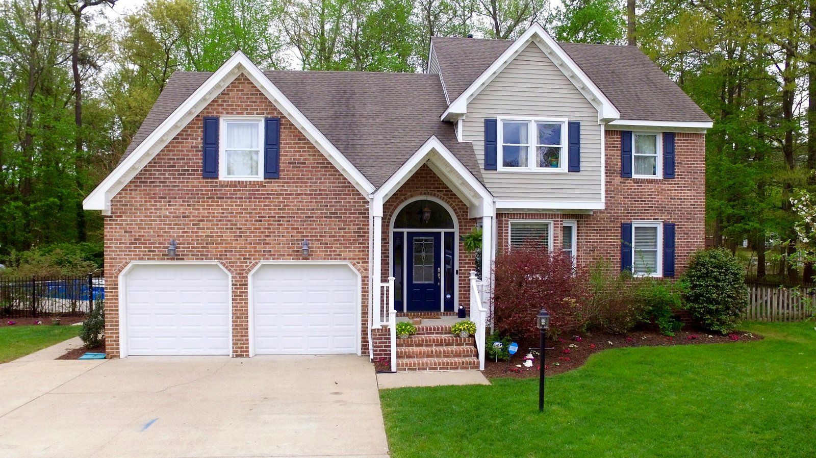 Brick two-story home with white gutters and downspouts