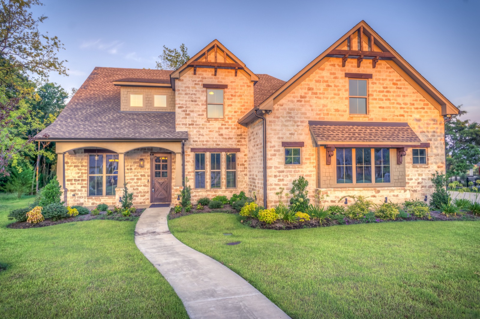 Stone estate with seamless gutters and a downspout pitched to the foundation