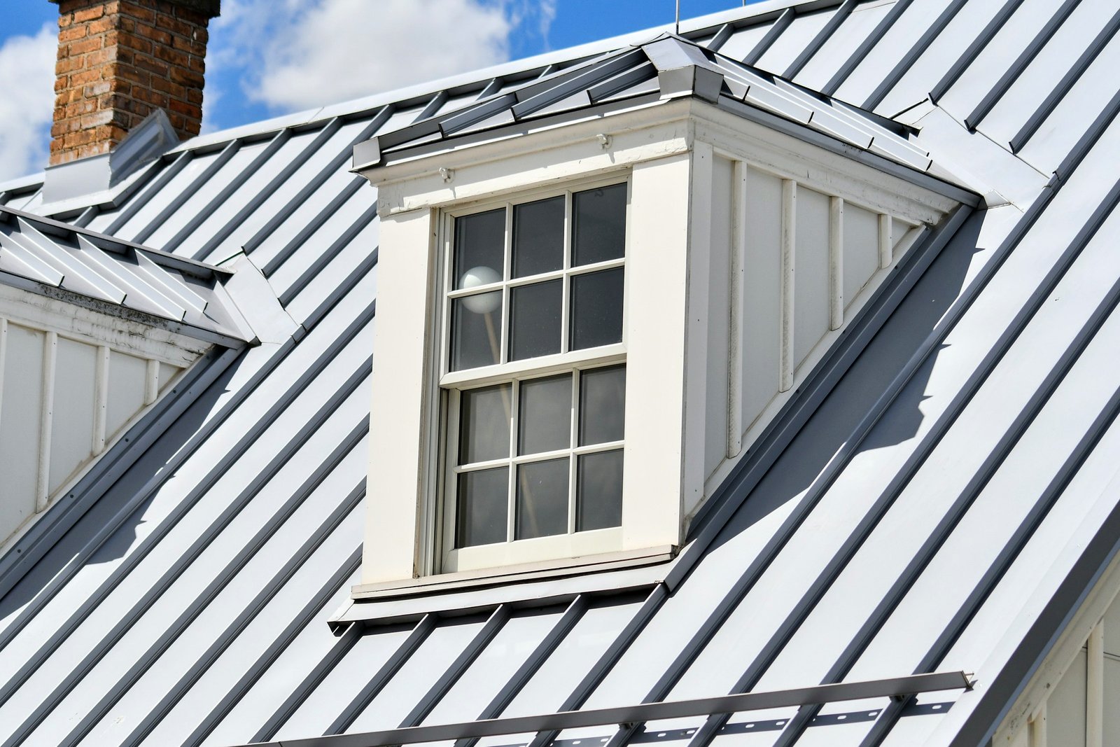 Standing seam metal roof around a dormer