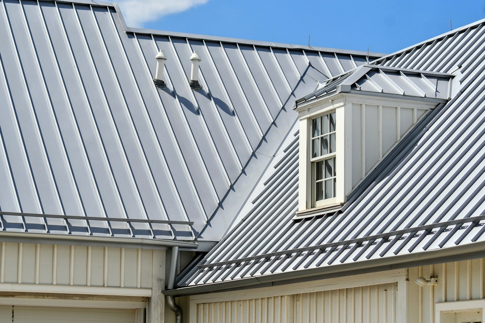 Standing seam metal roof with a dormer and pipe boots