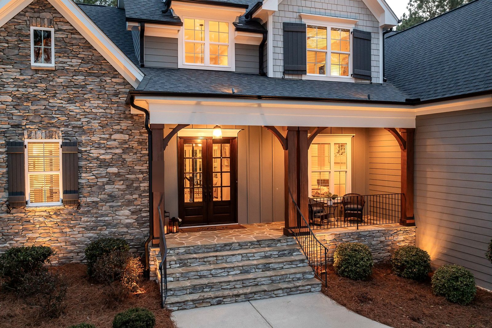 Board-and-batten and lap siding with wood-grain texture around a lit front porch