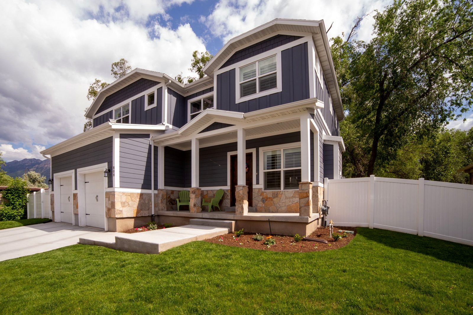 Navy fiber cement lap, shake and board-and-batten siding on a craftsman home