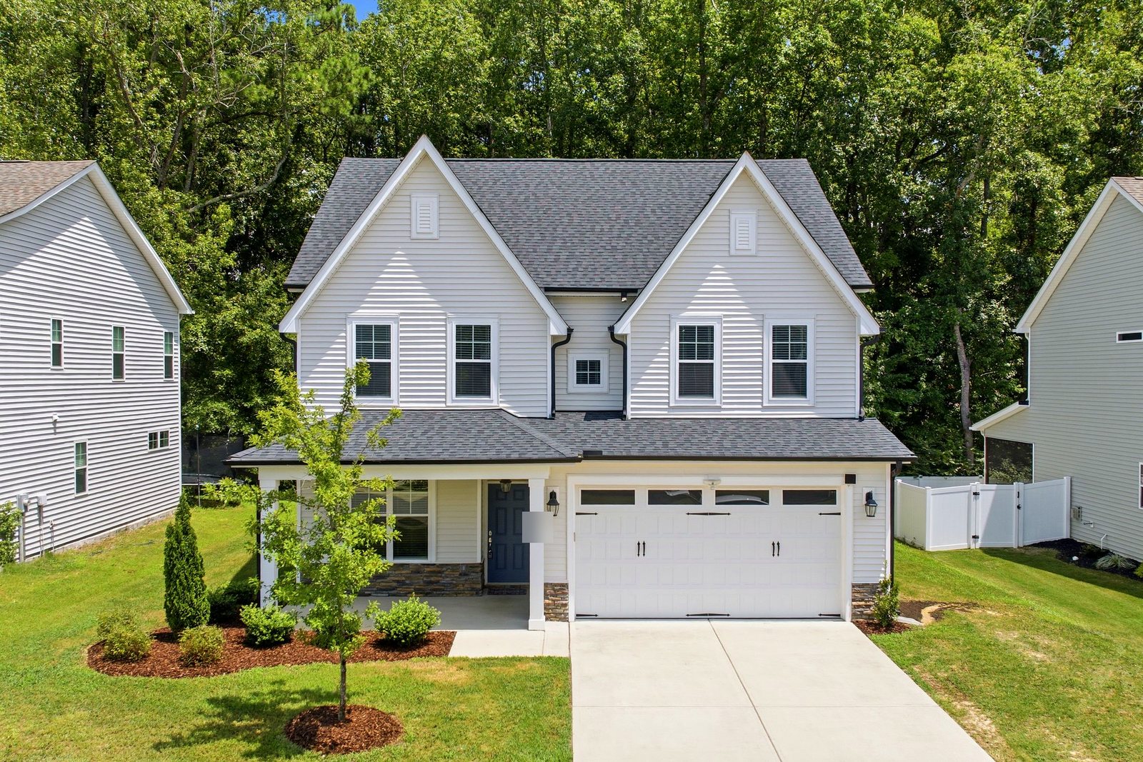 New two-story home with pale gray lap siding and a two-car garage