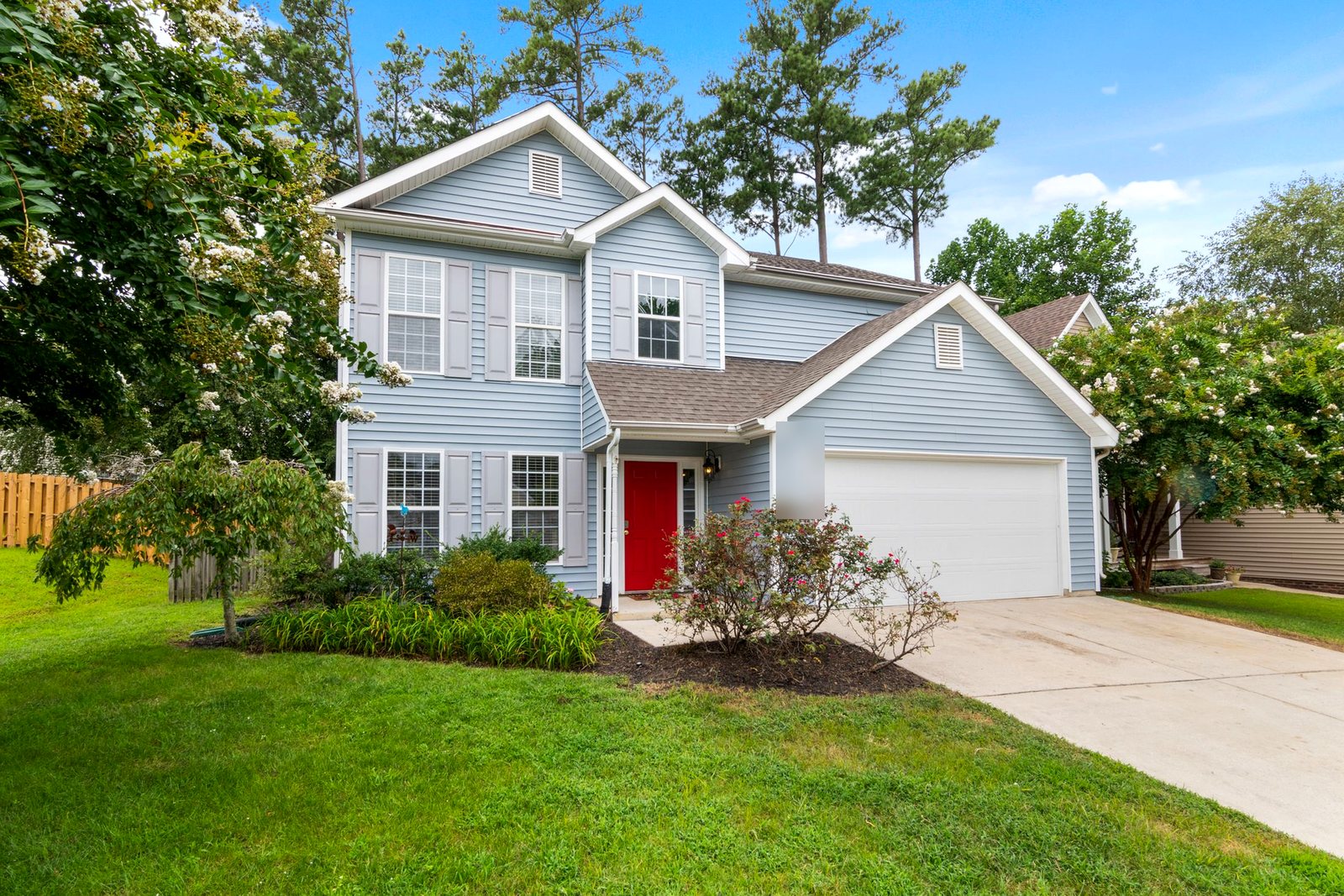 Two-story home with light blue vinyl lap siding and white trim