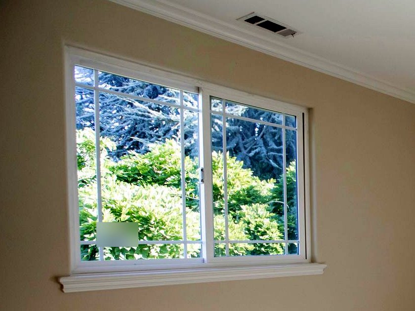 White horizontal slider window with grilles