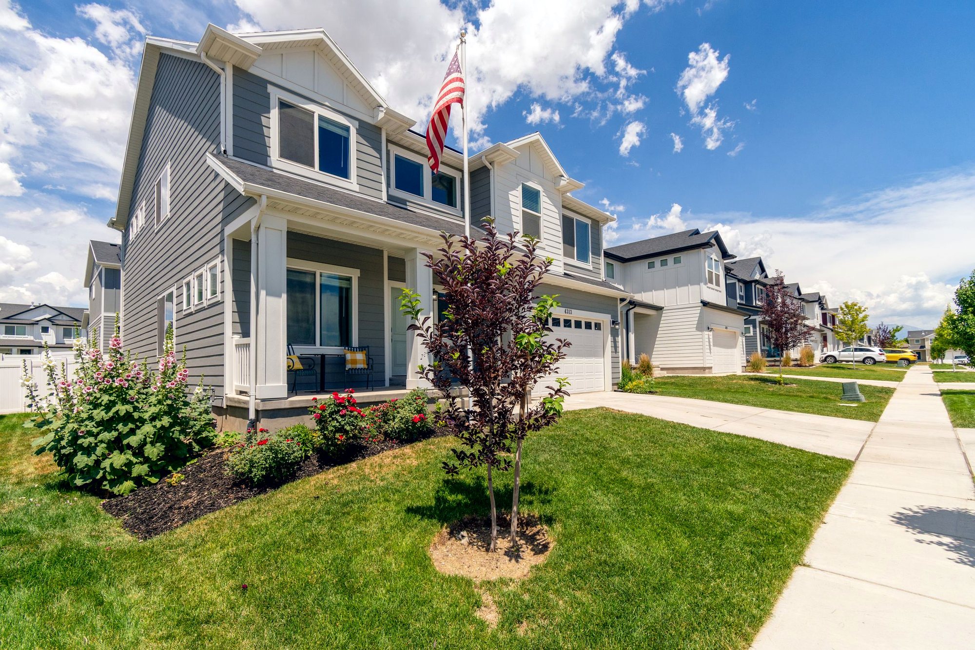 New two-story home with rows of white-trimmed windows and a covered porch
