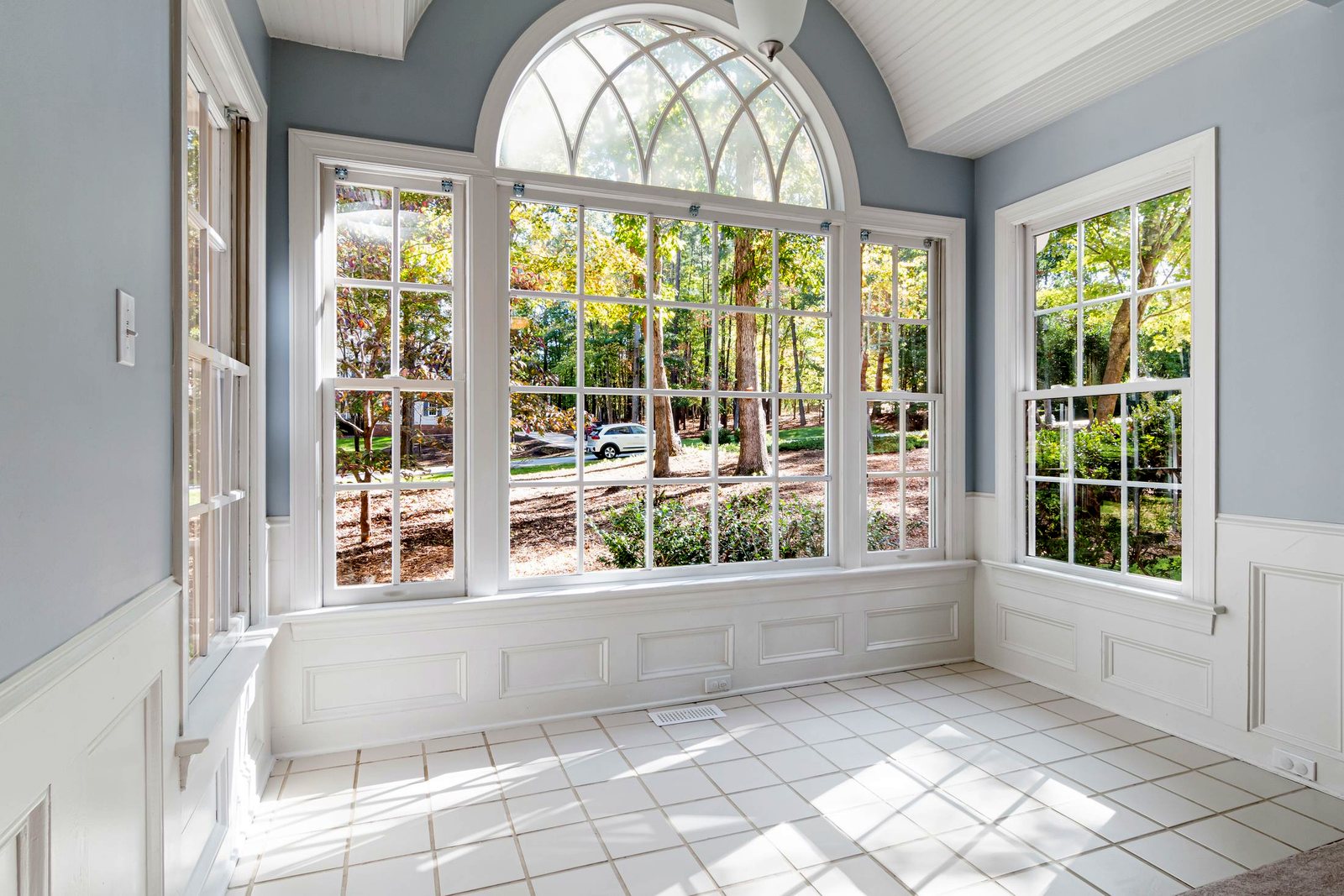 Sunroom with an arched picture window flanked by double-hung windows